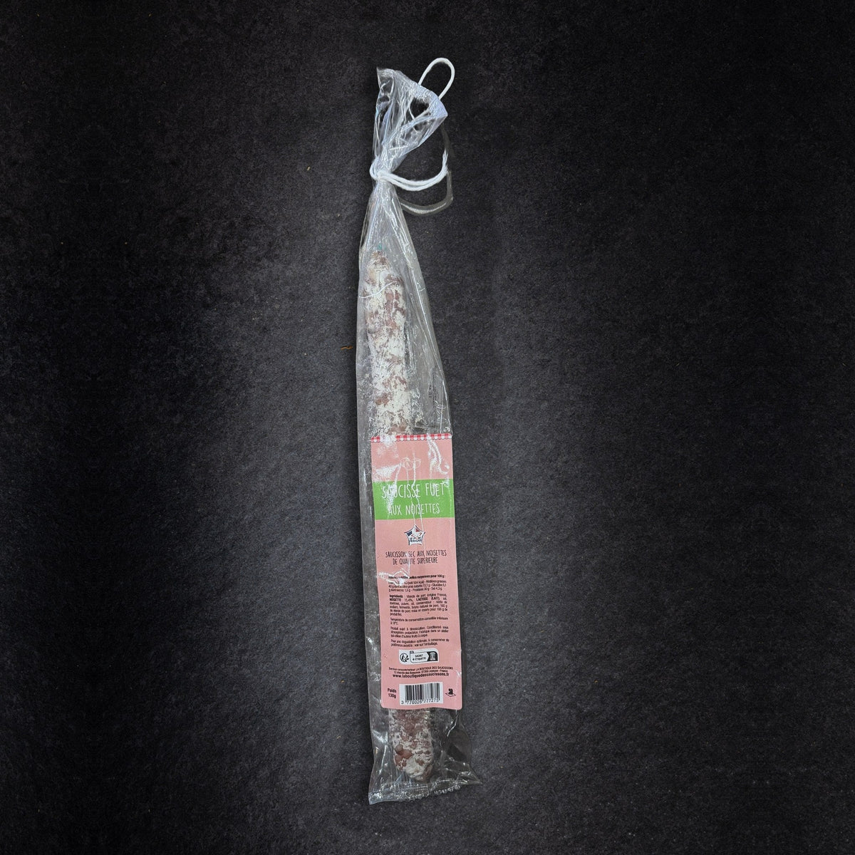 Fuet aux noisettes La Boutique des Saucissons en sachet de 130 g, présenté sur une ardoise noire