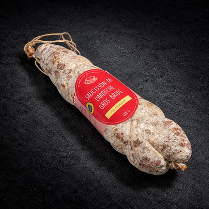 Gros saucisson bridé de l'Ardèche IGP 480 g, ficelé à la main, avec son étiquette, sur fond d'ardoise noire
