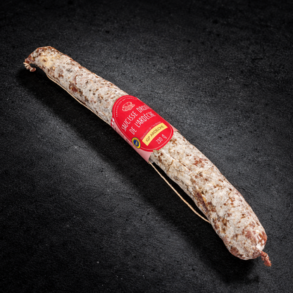 Saucisse droite de l'Ardèche IGP 230 g avec son étiquette, sur fond d'ardoise noire