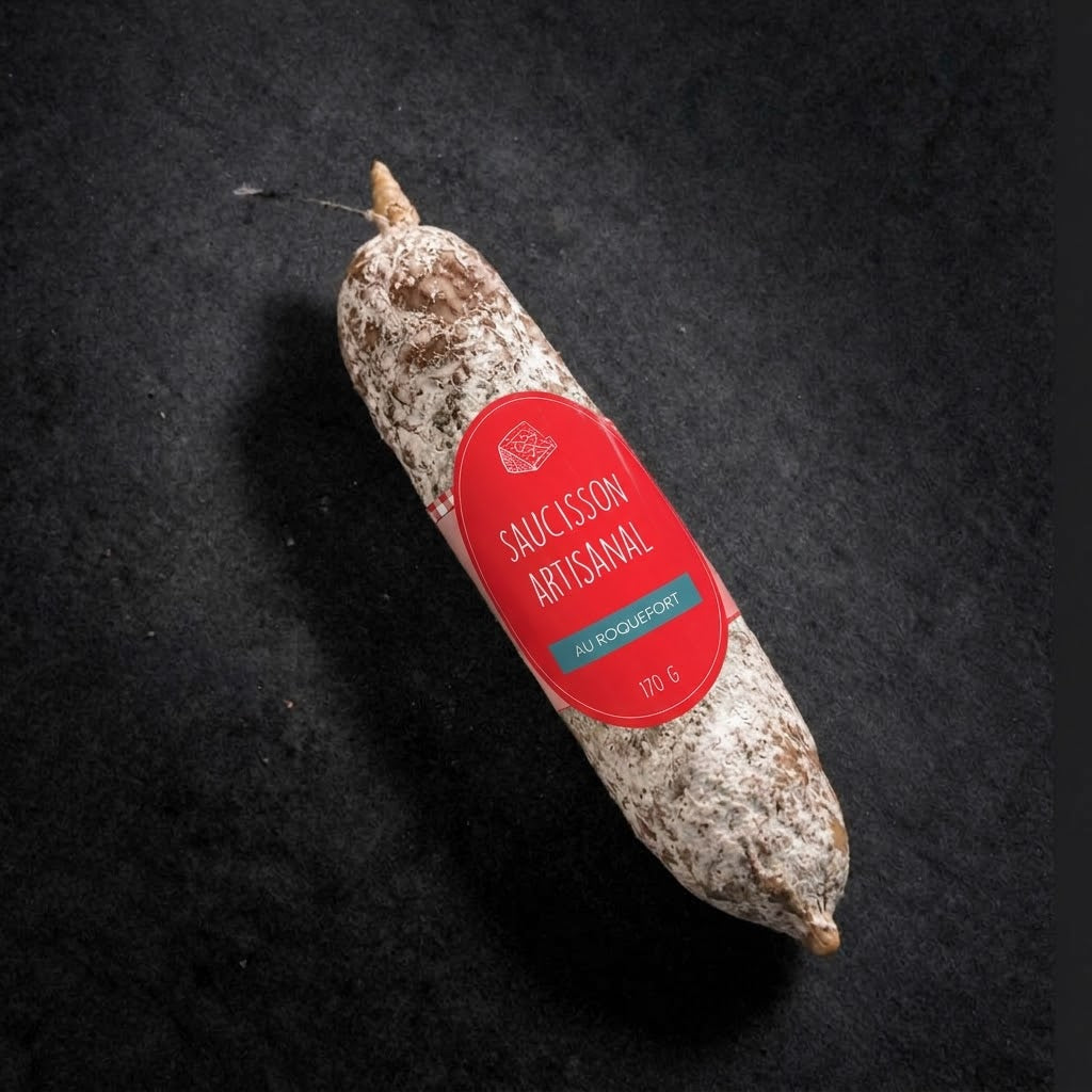 Handwerkliche Trockenwurst mit in die Wurst eingearbeitetem Roquefort, 170 g, mit Etikett auf schwarzem Schiefer